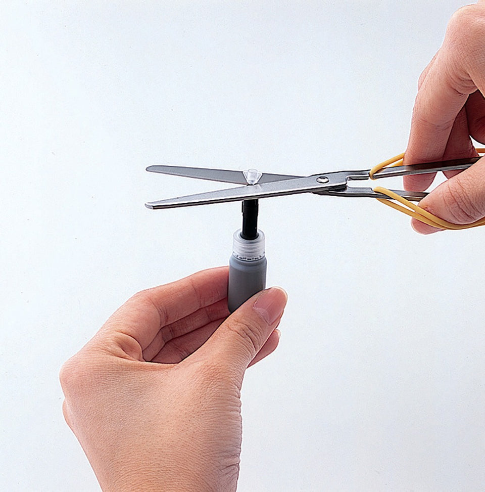 Inserting the ECO-GREEN refill nozzle into the marker body and squeezing to inject the ink