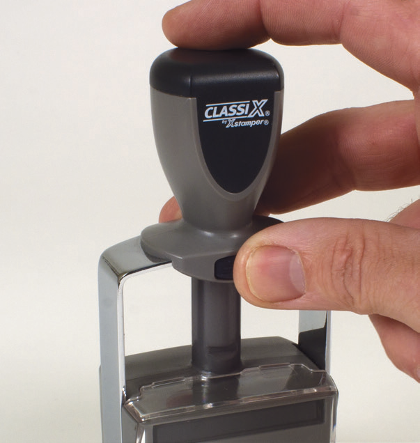 Pressing down on a ClassiX stamp and releasing the black locking button on the front