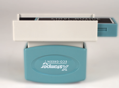 Sliding the impression cartridge out of the handle of a rectangular Xstamper ECO-GREEN message stamp