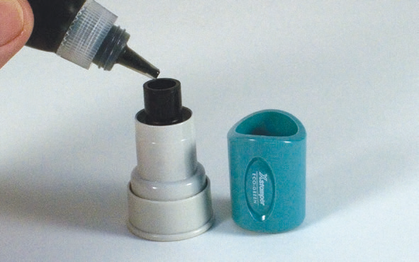 Removing the handle of a cylindrical Xstamper round stamp and adding refill ink to the opening in the centre of the mount