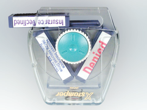 Sliding the impression cartridge out of the handle of an Xstamper Spin'N Stamp