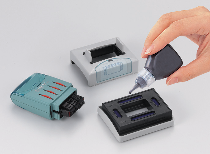 Placing drops of Xstamper ink into each channel of the VersaDater impression cartridge