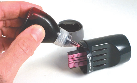 Adding refill ink to the inking hole of an Xstamper vX date stamp